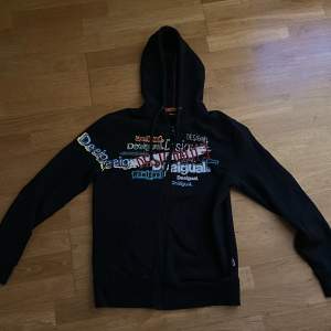 Svart zip hoodie från Desigual med sydda och vanliga tryck på framsidan.  Köpt för 1400kr 