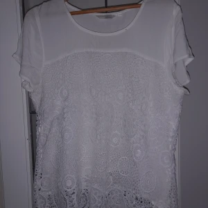 Vit mönstrad t-shirt  - Hej  Säljer en vit mönstrad t-shirt med en tunn inne tröja under de mönstrade tyget, använd några fåtal ggr men fortfarande i gott skick. Storlek L , finns i eslöv att hämta kan med skickas frakt tillkommer. Tar swish och kontanter.