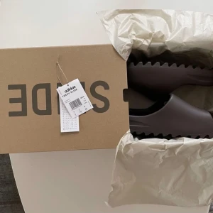Yeezy Slides Sloot - Helt nya oanvända Yeezy slides i storlek 43 färgen Sloot som fortfarande ligger i förpackningen. Skickas antingen mot frakt eller hämtas upp i Göteborg.