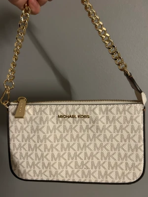 Michael Kors Kuvertväska - En kuvertväska från MK köpt på Zalando i Maj, använd endast en gång och det var på studenten. Har ej så mycket användning för den längre och därför säljer jag den. 