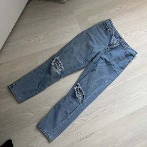 Jeans - Blå högmidjade boyfriendjeans från Boohoo med håligt vid knäna. I gott skick! strl. 38. Samfraktar gärna! Kolla in mina andra annonser om det finns något av intresse!