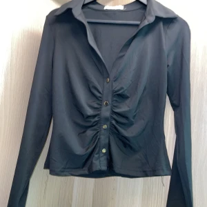 Topp med knappar - Svart topp med guldiga knappar Använd en gång 