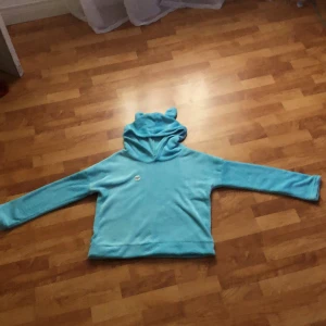 Tjocktröja - Det är en fluffig ljus blå tjocktröja .