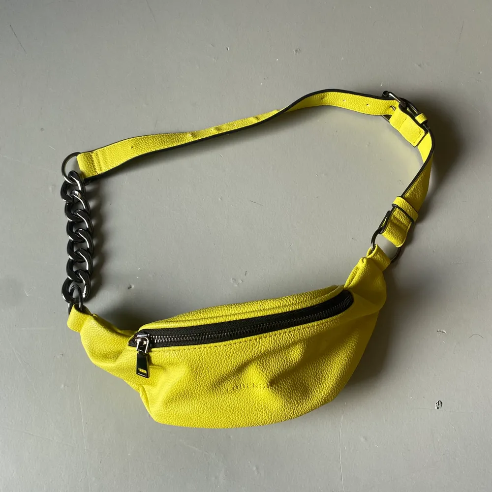 En gul magväska som är köpt i en butik i Tyskland.. Väskor.