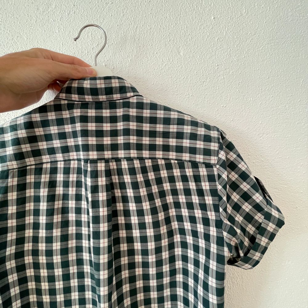 Ca. 2010 forest green tartan shirt with folded sleeves held up with a buttoned strap. Mens size S but fits like XS. Sparingly used, but there is an 8mm tear by the 3rd button from the top. Not visible and easily fixed.. Skjortor.