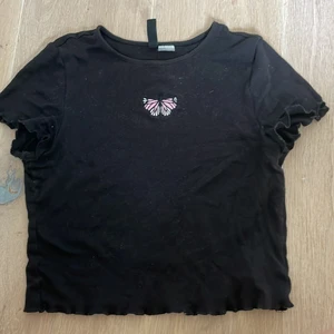 Svart topp - En svart topp från hm med en rosa fjäril på, säljer den för att den aldrig används då jag hellre använder andra tröjor. Köparen står för frakt, hör av er vid frågor💕
