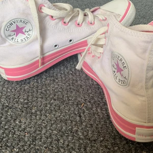 Converse vita - Höga vita Converse med rosa detaljer. Köpta secondhand på Stadsmissionen men fel storlek så inte använda. Väldigt bra skick inte slitna alls, några små fläckar (se sista bilden).