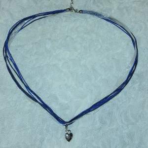 Halsband med snören i olika blåa nyanser och ett avtagbart silvrigt hjärtformat hänge🫶🏻💞💞ej äkta silver! (frakt med frimärke ligger på 14kr, billigare frakt)!