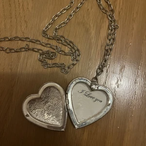 Halsband med hjärta - Jättefint halsband med ett hjärta som man kan öppna, man kan till exempel lägga in en bild eller text där. Just nu står det ”I love you”. Man kan även fixa kedjan om den är för stor. Jag säljer den då den inte kommer till användning. 