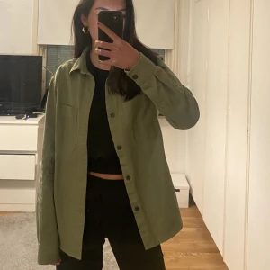 Grön overshirt - Säljer denna gröna overshirt från H&m. Den är i storlek XS, men sitter som en S och man kan även ha en tjockare tröja under. Säljer då den inte kommer till användning längre (säljer en likadan i svart) 