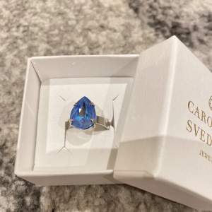 FRI FRAKT-frimärken💗Säljer min fina ring från Caroline svedbom i en fin blå färg. Ringen är i fint skick och endast använd vid 2 tillfällen💗säljer då jag har för många ringar. Nypris: 495kr