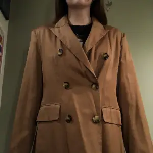 Jättefin ljus brun kort trench coat från Gina Tricot.