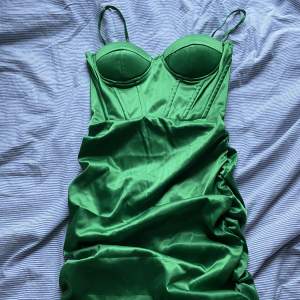 Säljer min jättesnygga figursydda gröna klänning i satin. Aldrig använd.