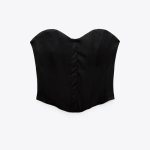 Zara korsett - Säljer en svart korsett topp från Zara i satin, helt oanvänd med lapparna kvar i storlek XS. Kan mötas upp i Göteborg eller skickas om köparen står för frakten😊 skickar självklart egna bilder vid intresse!