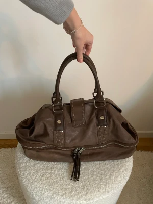 Brun mango väska äkta läder  - Brun stor väska i 100% koläder. Vintage, använd med nån skavank, se bilder. Kan användas som mindre weekendväska eller vardagsväska med plats för dator mm.