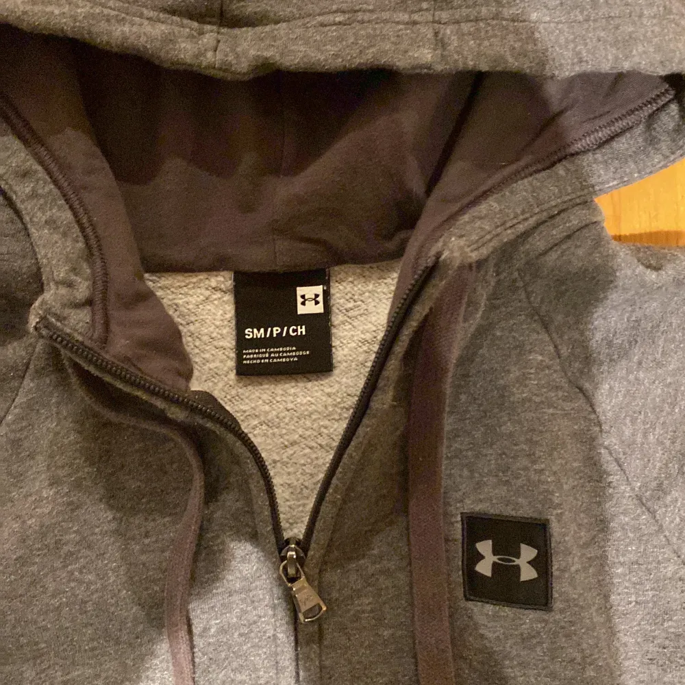 Säljer en grå zip hoodie från under armour, storlek S. Den är aldrig använd, den är i nyskick och inga fel på den. Skicka dm för frågor eller fler bilder. Köparen står såklart för frakten.. Hoodies.