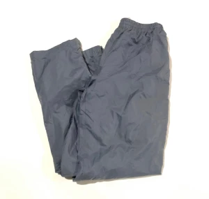 Windbreaker trackbyxor - Vintage 90s Fila Windbreaker Track-Pants-Medium. Retro 1990s Pastel Grey Nylon byxor. Är i bra skick. Köptes från en kanadensisk affär som säljer vintage kläder. Kvitto finns. Köptes för 599kr. Strlk M