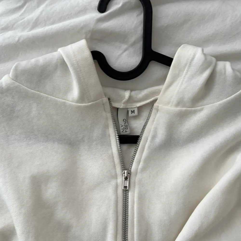 En vit croppad hoodie från Nelly i strl M! Superfint skick då den bara är använd några få gånger 🤍🤍 . Hoodies.