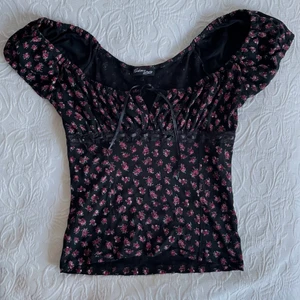 Blommig top - En jättefin milkmaid top köpt här på Plick som tyvärr är för stor för mig, hann aldrig komma till användning. Den har satinband som man kan knyta där fram och är lite mer öppen vid bysten. Den är lite korsettaktig då den har band runt, i jättefint skick! 