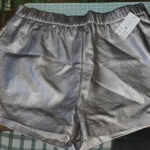 SHORTS STRL 36/S GINA TRICOT  - Helt nya shorts från Gina Tricot. Storlek 36/S. Färg: Silver. Nypris: 299 kr.  Jag har inte ens provat dem då de inte är min stil. 