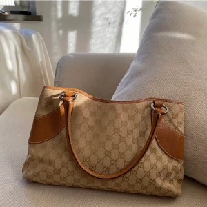 Gucci väska - Äkta Gucci med kod som kan skickas vid önskan. Köpt från the vintage bar. Måtten är Längd: 35,5cm Bredd: 6cm Höjd: 20cm