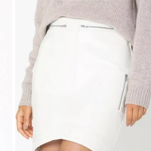 Kjol  - Kort vit kjol med dragkedja-detaljer, från Missguided köpt från Nelly.com. Material: läderimitation. Dragkedja bak. Storlek 34. Kan även skicka om önskas, fraktalternativ kan diskuteras.