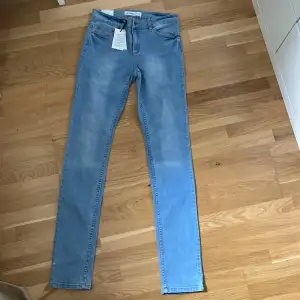 Oanvända ljusblå jeans