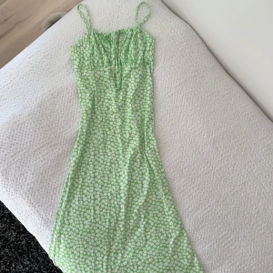 Grön lång figursydd blommig klänning - Säljer denna superfina långa klänning från shein! Den är aldrig använd och är i superfint skick! Den sitter superfint på kroppen då den är tajt och figursydd💚