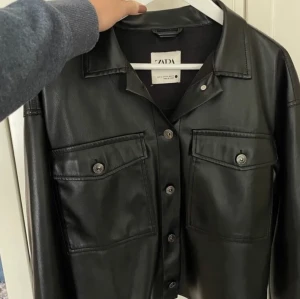 Skinnskjorta - Säljer denna skjorta i skinnimitation från Zara, använd två gånger så som ny😊 Kan bäras både öppen och stängd samt användas som tunnare jacka på våren!