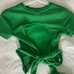 Ribbad topp med öppen rygg.  - Grön söt topp med öppen rygg & knyte. Jättebra skick! 