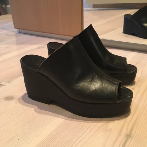 Svarta platåskor - Snygga svarta höga platåskor. Gott skick. Storlek 40 men passar även på mig med 37 då det är som en sandal. 