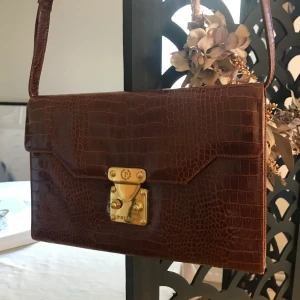 Pollini axelväska - Mörkröd pollini väska med långt band.