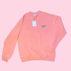Oversized bright warm pink sweatshirt with a green “Take Care” logo. It’s color is brighter in real life with a slightly neon-ish shade. Size: M, oversized fit, unisex. Condition is brand new, with a tag. 