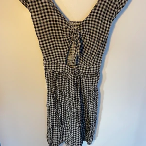 Hollister klänning - Rutig klänning i svart/vitt från Hollister, tight upptill och sitter löst nertill  Kund står för frakt, inga byten