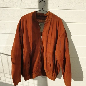 Vintage Bomberjacka i Mocka - Säljer en vintage bomberjacka i mocka. Jag finner dessvärre ingen storlek, men jag skulle säga att den passar dem som har storlek M-L. Eftersom den är vintage har den små slitningar (se bilder), men sin helhet är jackan i bra skick.👌 