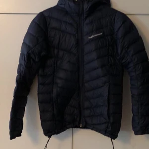 Peak performance jacka XS - Storlek XS mörk blå peak performance jacka, finns ett litet håll på luvan, och ett större håll i Fickan på höger sida som syns på bilden. Kan skickas bara du står för frakten och kan få mer bilder. 