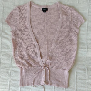 Rosa virkad topp/kofta - Fin gammelrosa virkad topp. Med knäppning och knytning nertill (man kan justera längden lite och få den att sitta fint i midjan). 55% akryl, 45% bomull. Storlek XS. Säljer en likadan fast vit i storlek S.