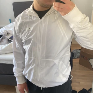 STELLA MCCARTNEY x ADIDAS vindjacka  - Säljer denna sparsamt använda vindjacka från adidas x Stella McCartney samarbetet dem hade. Finns även kvitto på varan som indikerar på att den är äkta. Storlek L och skulle säga att den passar en M möjligtvis en S beroende på hur man vill ha passformen.  