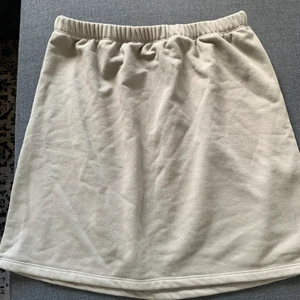 Fin kjol från nakd  - Säljer denna fina kjol som är i en beige/grå färg och i ”mjukis”material vilket gör den väldigt skön. Den är använd max 5 gånger så i princip nyskick 🌷