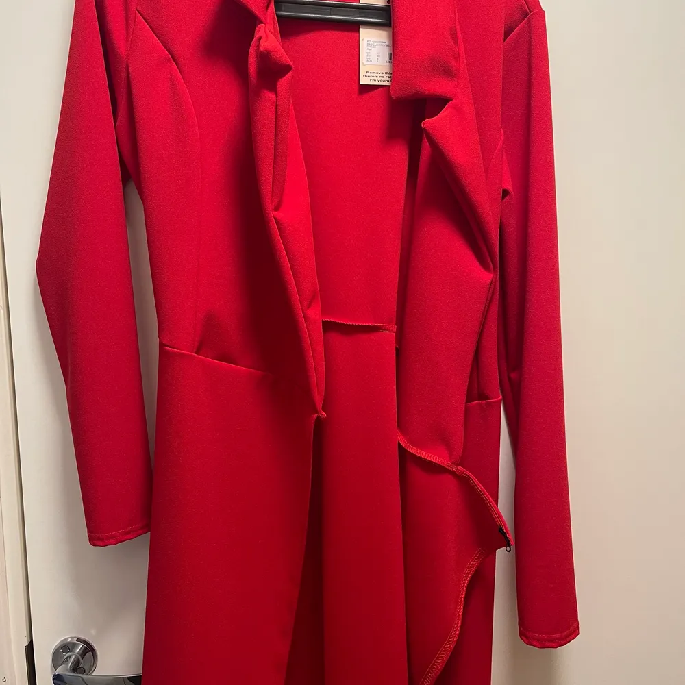 Klänningen är röd och är i storlek 40. Köpt för ca 1 månad sedan och helt oanvänd sedan dess. Köpt för 280kr. Klänningen går även att använda som kappa/blazer . Klänningar.