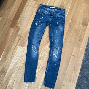 Slitna detaljer jeans strl 32 xxs  - Lågmidjade jeans sitter väldigt bra rätt tajta i storleken  bra för min längd som är 155 sälja pga för små för mig 