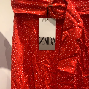 Långkjol från Zara - Röd kjol med vita prickar från zara. Aldrig använd med prislappen kvar. Storlek S.