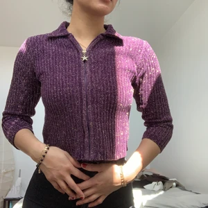 Glittriga kofta - Lila kofta med en stjärna på dragkedjan. I barnstorlek därmed trekvartsärmar och cropped, men ser inte konstigt ut iom mycket stretch