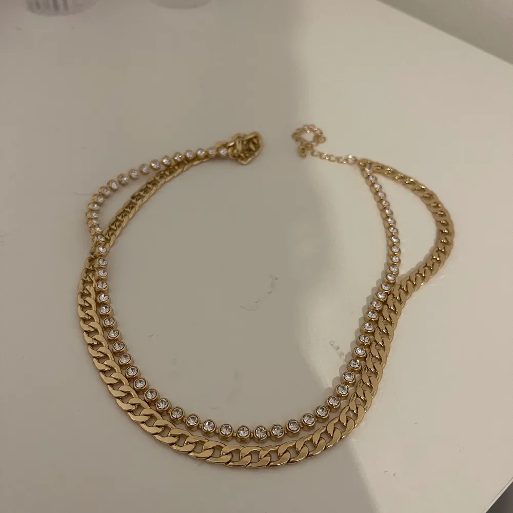 Guldigr Dubbelhalsband med en tjockare kejda och en med små diamanter. Från ginatricot.  Helt oanvänd. Köparen står för frakt . Accessoarer.