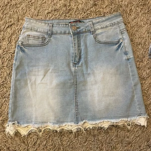 Jeanskjol - Jättesöt jeanskjol med spets längst ned och små rhinestones. Står storlek 44 men passar jättebra på mig med 34! 