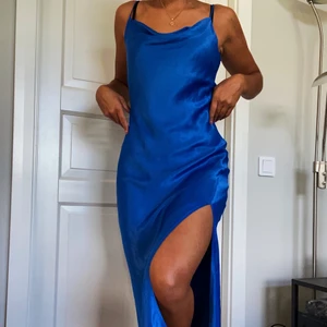 satinkklänning - Oanvänd klänning i satin, fall i fram och slits på vänster sida. Justerbara axelband. Slutar ungefär 15cm från marken (lite över ankeln) på mig som är 175. Om många är intresserade kan det bli budgivning