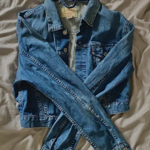 Blå Levis jeansjacka  - Säljer en blå vintage Levis jeansjacka sparsamt använd, den är ganska kort o ärmarna ganska långa