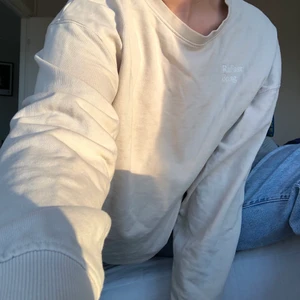 Oversize tröja i beige/creme vit - Stilren sweater från Weekday. Liten text där det står ”Radiant Being”. Mycket bra skick. 