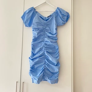 Blå klänning Gina 36 - Ljusblå rynkad / draperad superfin somrig klänning från gina tricot. Storlek 36/S. Dragkedja baktill på ryggen. Superbra skick!