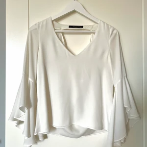 Blus från Zara - Vit och luftig blus från Zara. Fin urringning både bak och fram på blusen! Något vidare armar som gör blusen luftig och fin🤍